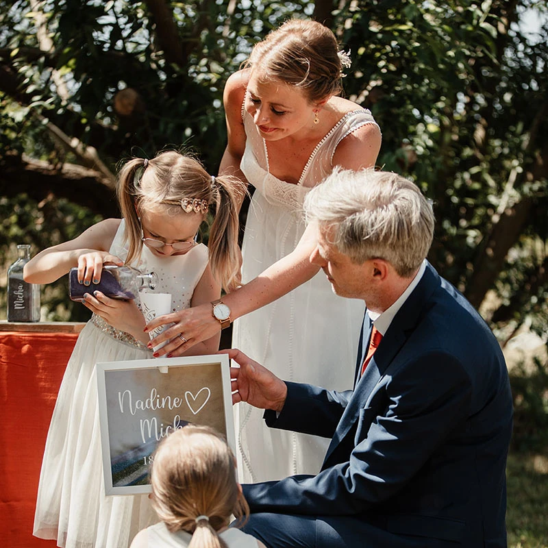 Eltern und Kinder Trauritual mit buntem Sand