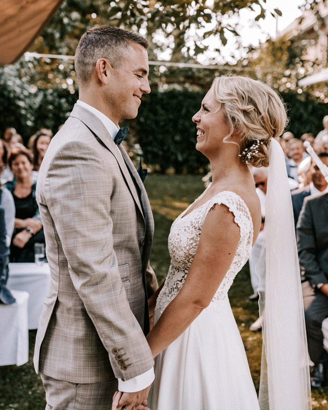 Hochzeitspaar hält sich während seiner freien trauung in berlin an den händen